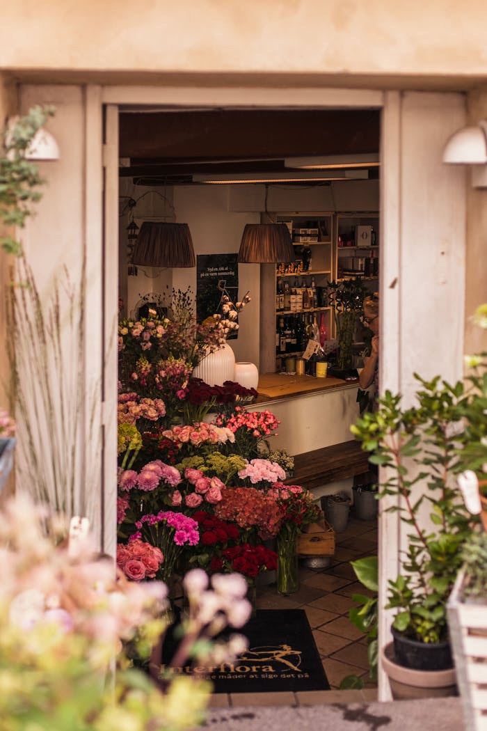 Charming entrance to a flower shop filled with vibrant roses and floral arrangements.