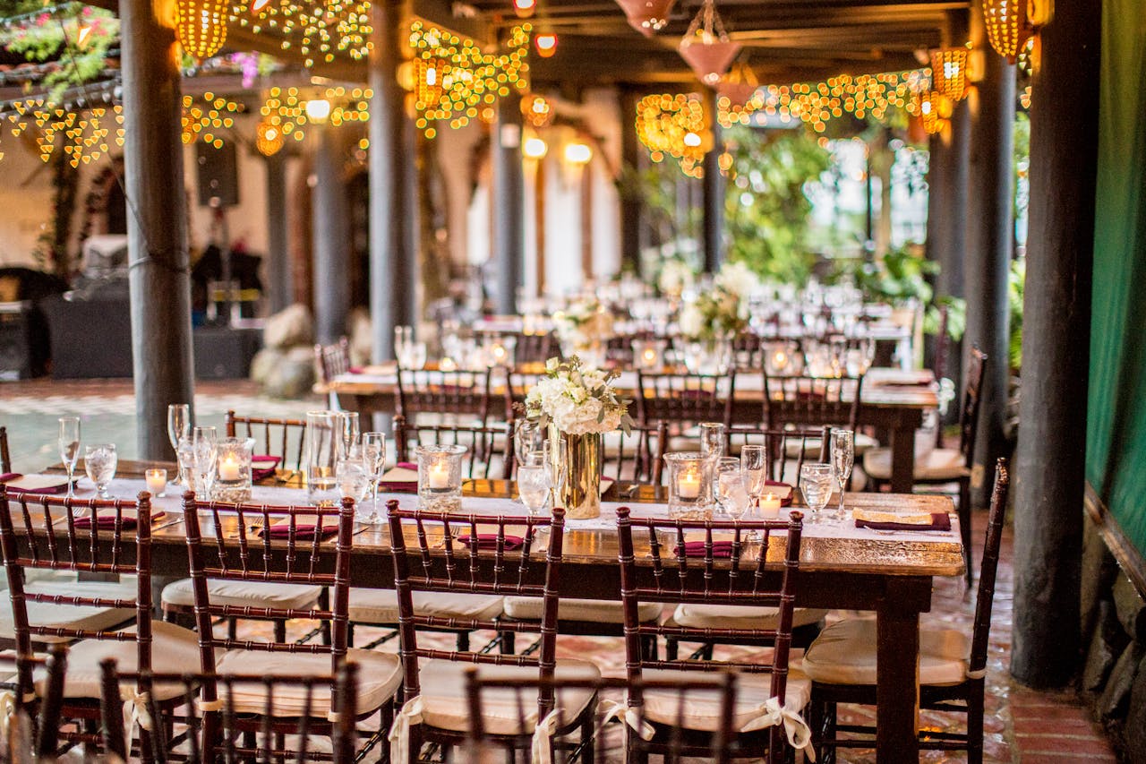 Charming outdoor dining setup with warm bistro lights and floral centerpieces.